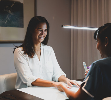 woman laughing while getting manicure at spa